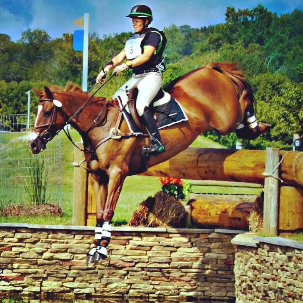 Cross country rider on back side of drop fence
